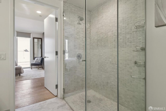 bathroom with marble finish floor and a shower stall