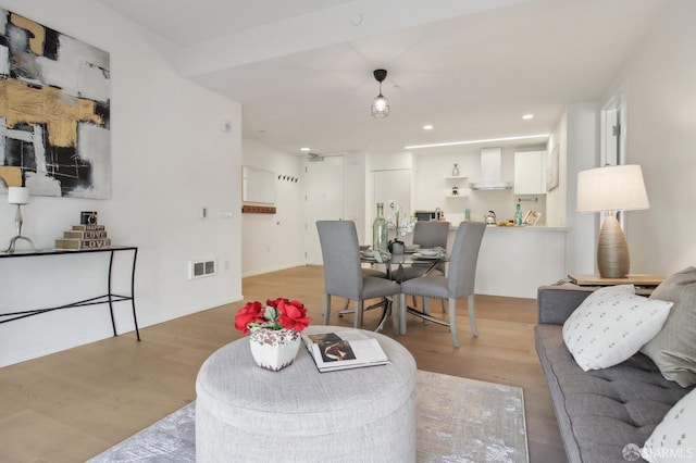 living room featuring wood finished floors, visible vents, and recessed lighting