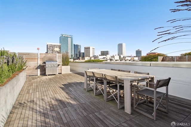 deck featuring a view of city and outdoor dining space