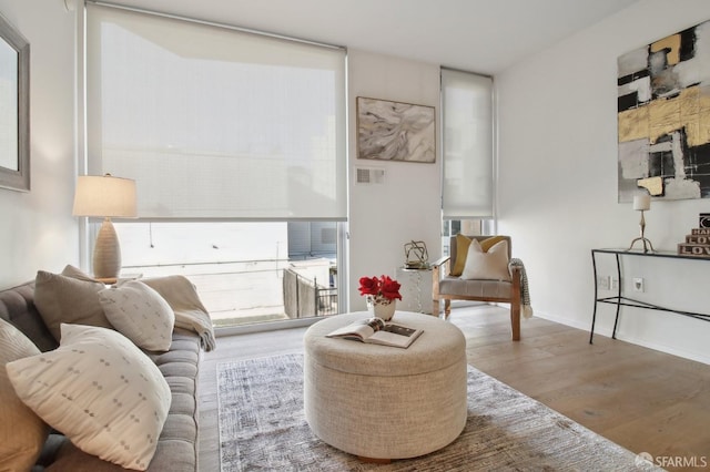 sitting room featuring baseboards, visible vents, and wood finished floors