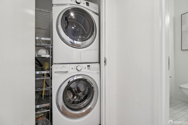 laundry room with stacked washer / drying machine, laundry area, and tile patterned floors