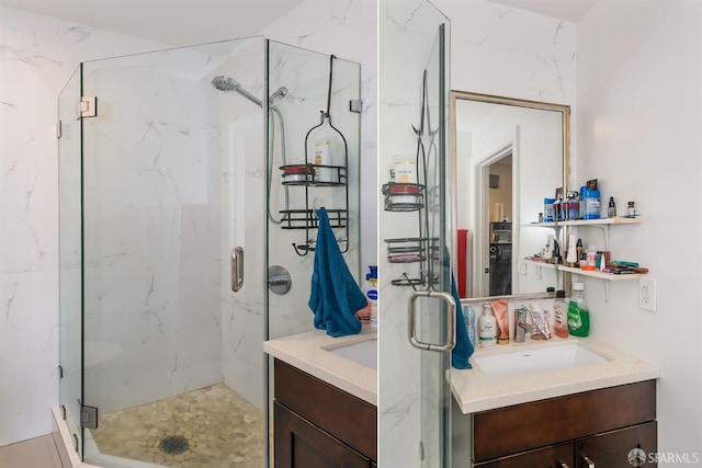 full bath featuring a marble finish shower and vanity