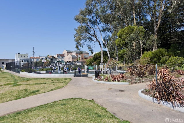 view of property's community featuring a yard, a residential view, and fence