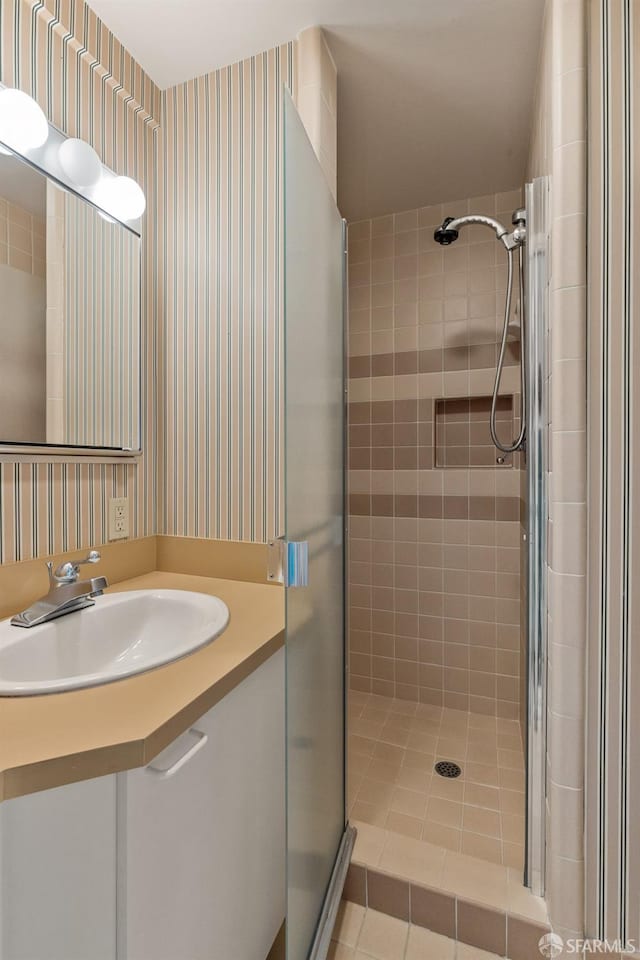 bathroom featuring tile patterned floors, wallpapered walls, and a shower stall