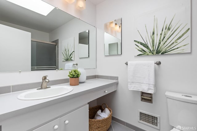 bathroom with vanity, tile patterned floors, toilet, an enclosed shower, and visible vents