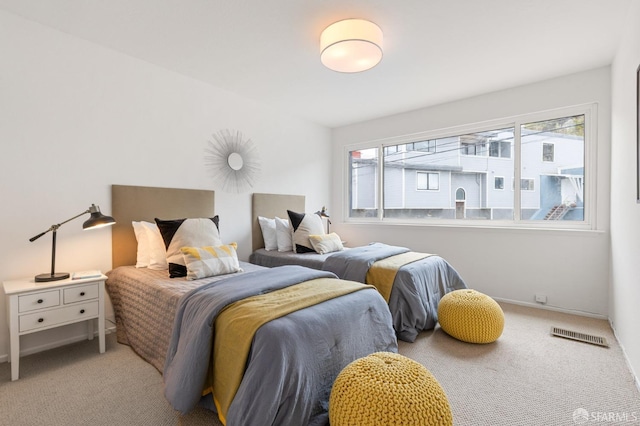 bedroom featuring multiple windows, baseboards, carpet, and visible vents