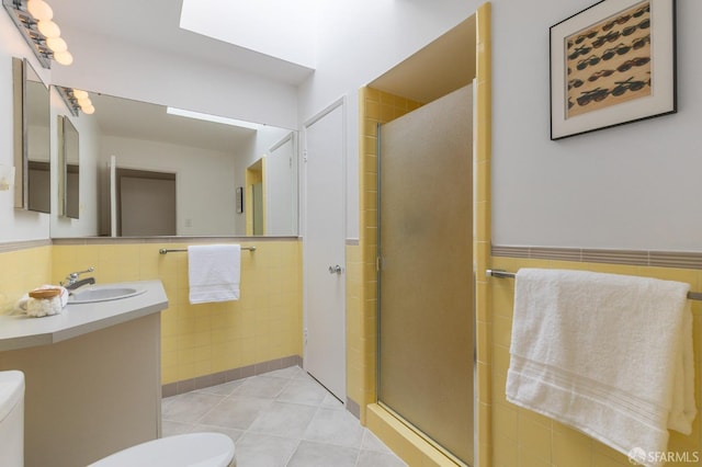 full bathroom featuring tile walls, a stall shower, toilet, and tile patterned flooring