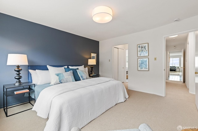 bedroom with baseboards and light carpet