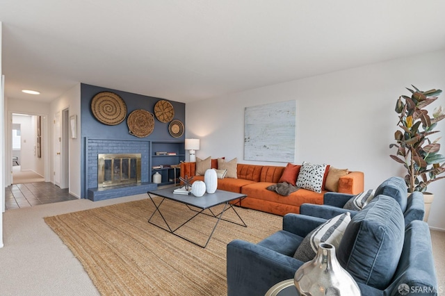 living area with a brick fireplace and carpet floors