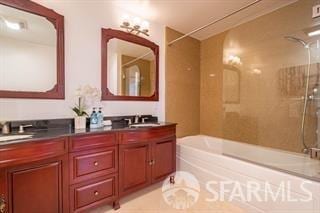 bathroom featuring tile patterned floors, vanity, and tiled shower / bath combo