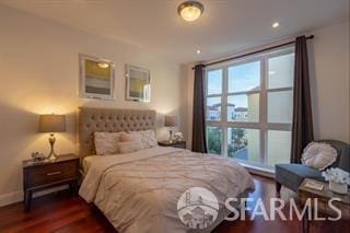 bedroom featuring dark hardwood / wood-style flooring and multiple windows