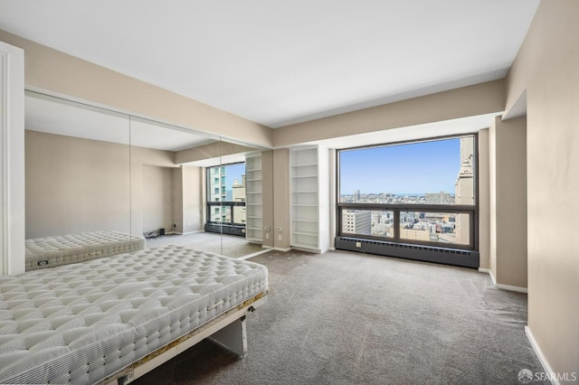 carpeted bedroom featuring a closet and a baseboard heating unit