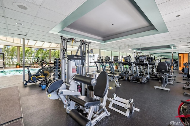 gym with floor to ceiling windows and a drop ceiling