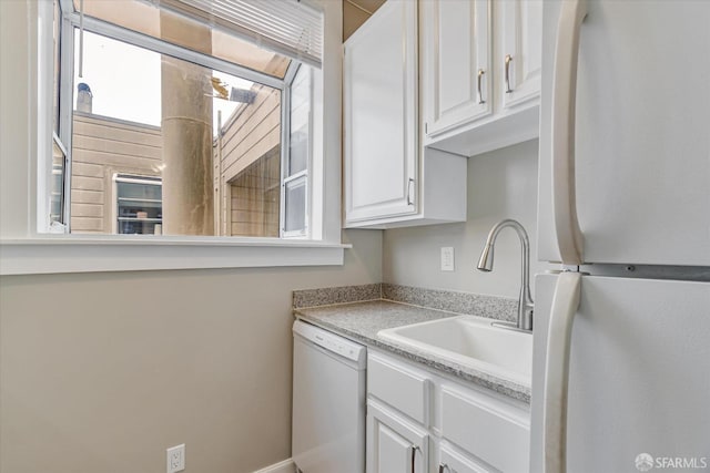 kitchen with white appliances, sink, and white cabinets