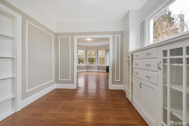 hall featuring built in shelves and dark hardwood / wood-style floors