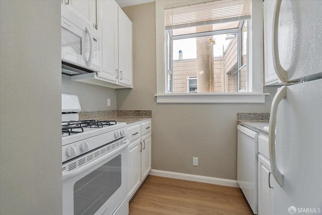 kitchen with white appliances, light hardwood / wood-style floors, and white cabinets