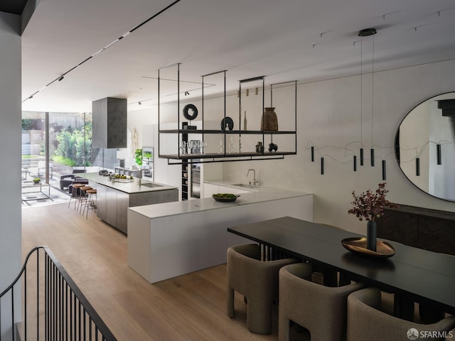 kitchen featuring light hardwood / wood-style floors, floor to ceiling windows, and sink