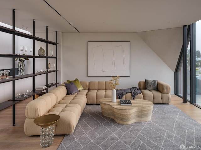 living room featuring wood-type flooring and a wall of windows