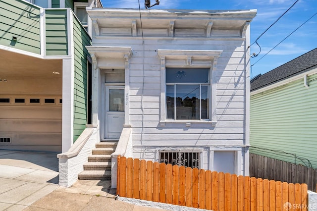 view of front of house with fence and a garage