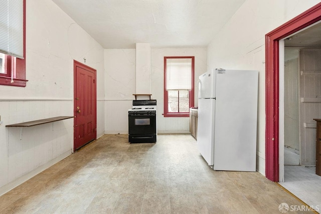 kitchen featuring gas range oven and white refrigerator