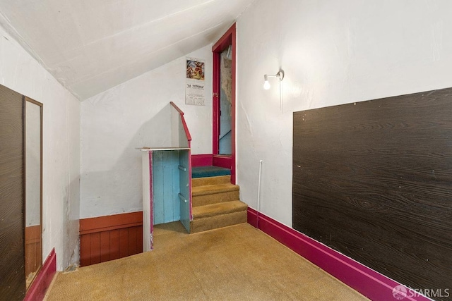 hall with vaulted ceiling and carpet floors