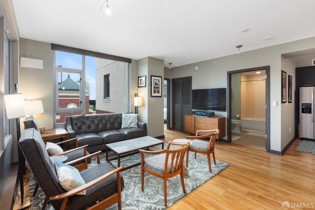 living area featuring baseboards and light wood-style flooring