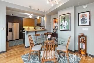 dining space featuring baseboards and light wood-style floors