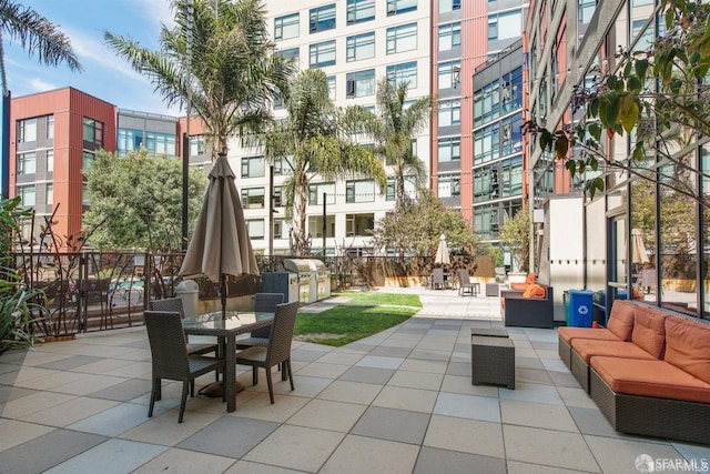 view of community with exterior kitchen, outdoor dining space, a patio area, and an outdoor hangout area