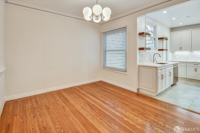 3675 Fillmore St Unit 102, San Francisco, CA 94123 - unfurnished dining area with a sink, a chandelier, light wood-style floors, ornamental molding, and recessed lighting