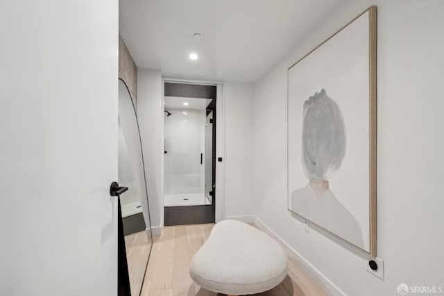 bathroom featuring wood-type flooring and a tile shower