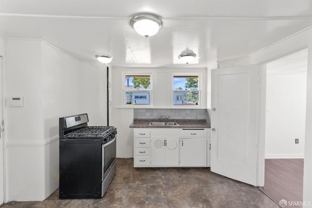 2875 Sunset Ave, Oakland, CA 94601 - kitchen featuring stainless steel gas range, dark countertops, white cabinetry, a sink, and backsplash