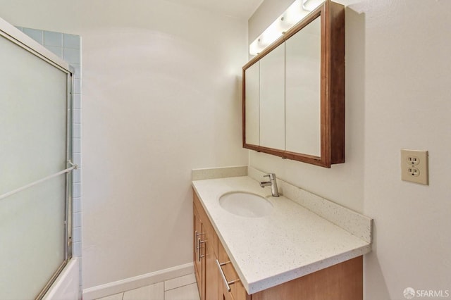 bathroom with enclosed tub / shower combo, vanity, and tile patterned flooring