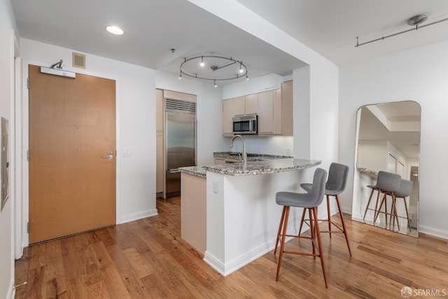 425 1st St Unit 3301, San Francisco, CA 94105 - kitchen with appliances with stainless steel finishes, a peninsula, a breakfast bar, and light wood-style floors