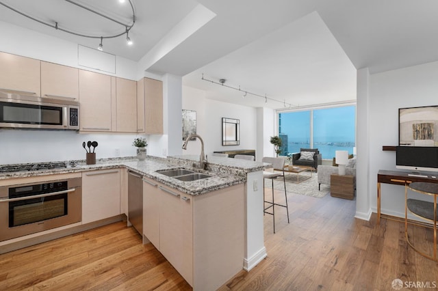 425 1st St Unit 3301, San Francisco, CA 94105 - kitchen featuring track lighting, appliances with stainless steel finishes, open floor plan, a peninsula, and light wood-style floors