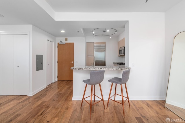 425 1st St Unit 3301, San Francisco, CA 94105 - kitchen featuring stainless steel appliances, a peninsula, light wood-style flooring, and a breakfast bar