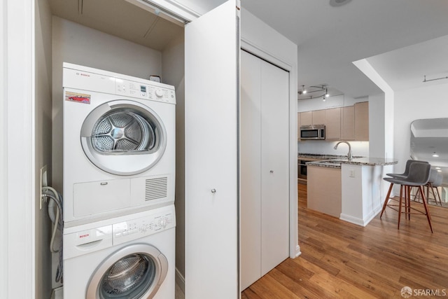 425 1st St Unit 3301, San Francisco, CA 94105 - laundry room with stacked washing machine and dryer and light wood-style flooring