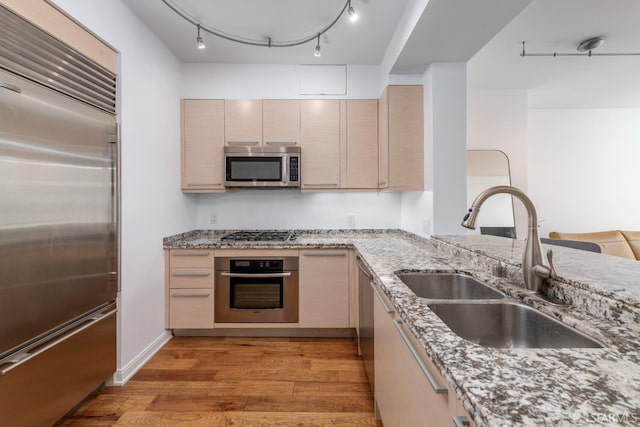 425 1st St Unit 3301, San Francisco, CA 94105 - kitchen featuring appliances with stainless steel finishes, light wood-type flooring, light stone counters, and light brown cabinetry
