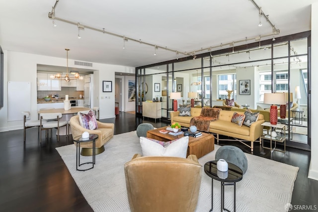 living room featuring dark wood-type flooring and a chandelier