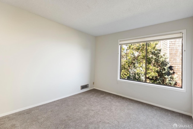 spare room with baseboards, visible vents, a textured ceiling, and carpet flooring