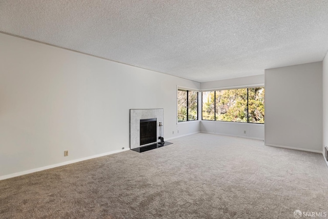 unfurnished living room featuring carpet, a fireplace, baseboards, and a textured ceiling