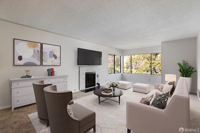 living room with carpet, baseboards, a textured ceiling, and a tiled fireplace