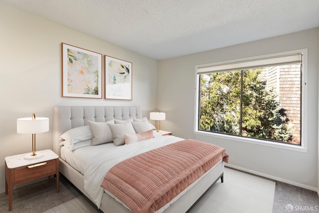 bedroom with a textured ceiling and baseboards