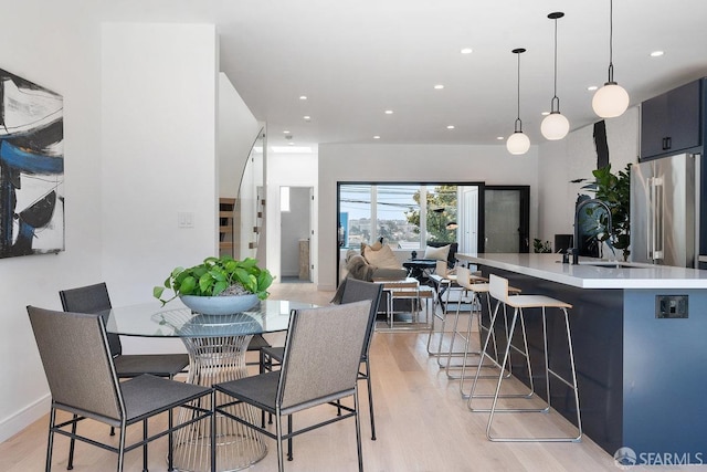 dining area with light wood-type flooring and sink