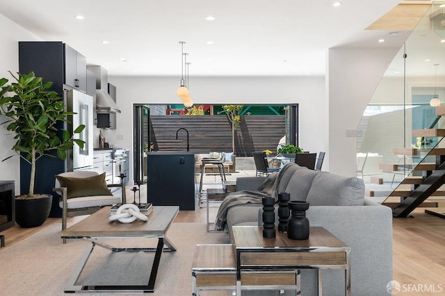 living room with light hardwood / wood-style flooring and sink