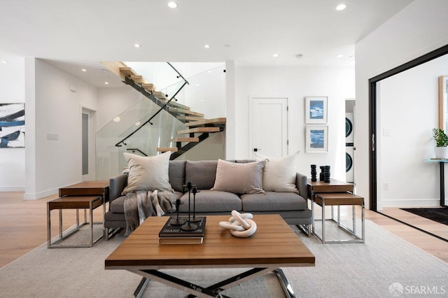 living room featuring light wood-type flooring and stacked washer and clothes dryer