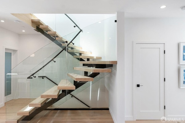 staircase with hardwood / wood-style floors