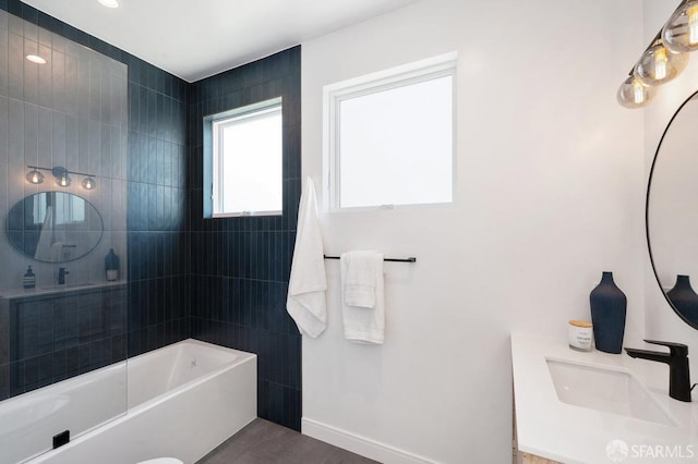 bathroom featuring vanity and tiled shower / bath