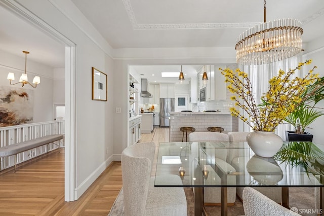 dining space with a chandelier and light wood-type flooring