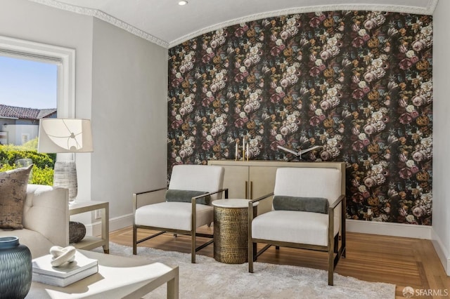 sitting room with crown molding and hardwood / wood-style flooring