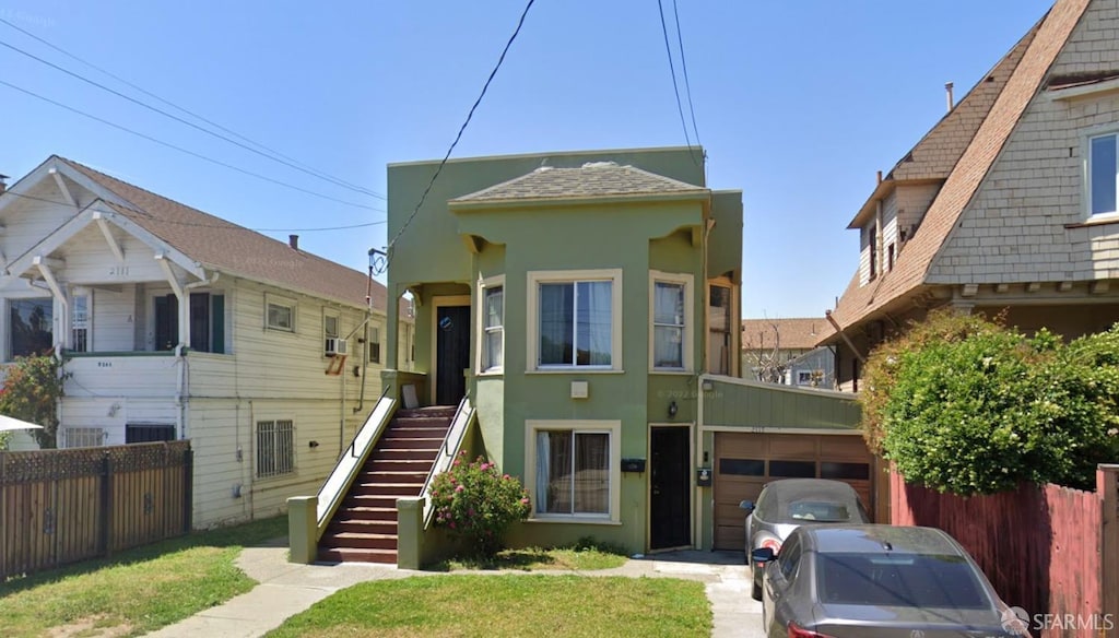 view of front of property featuring stairs, fence, and stucco siding